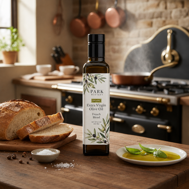 Bottle of Park Extra Virgin Olive Oil on a kitchen counter with bread and herbs.