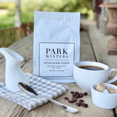coffee product on wood table with napkin coffee mug and sugar cubes with spilled coffee beans