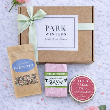 Gift set from Park Winters with tea, soap, and hand salve on a textured surface.